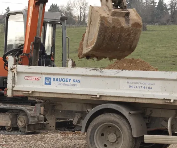 Une pelle Saugey réalise les fondations d'un bâtiment agricole